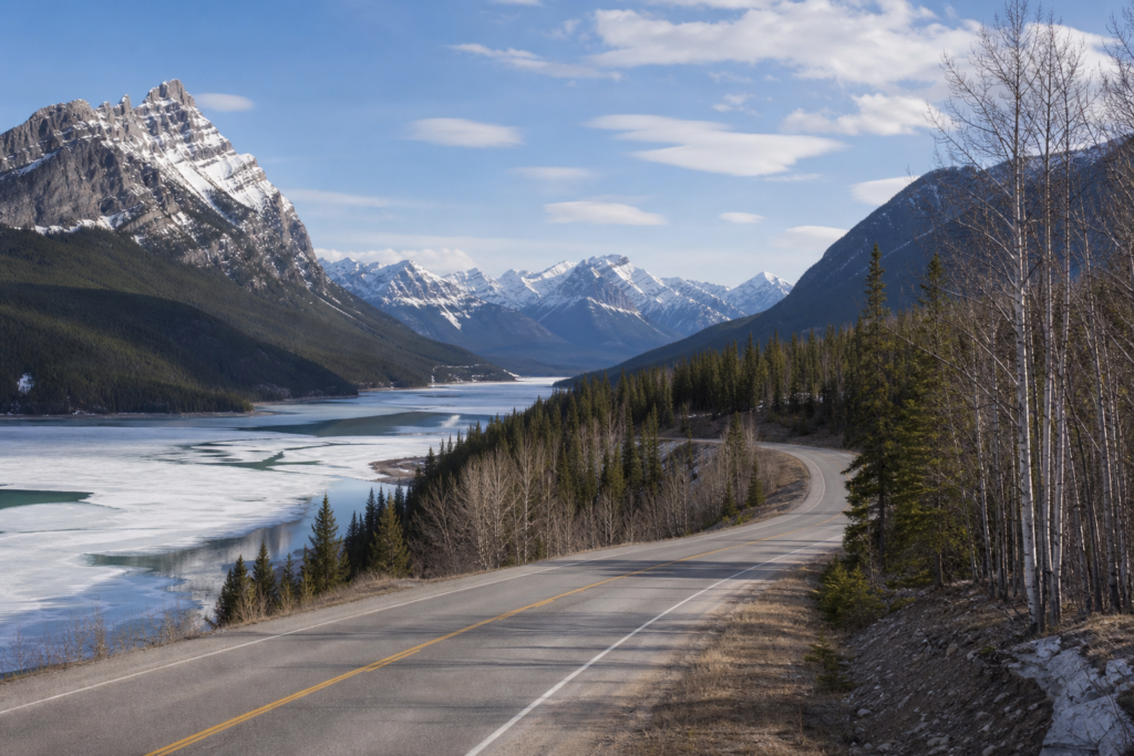 Quiet Banff April lake thaw and empty mountain road